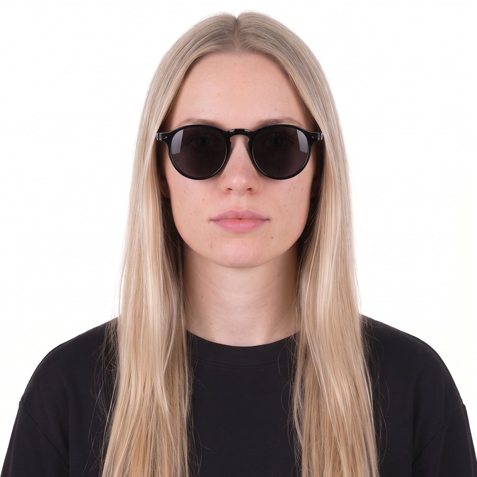 A woman with long blonde hair wearing black sunglasses and a black t-shirt, photographed against a solid white background.